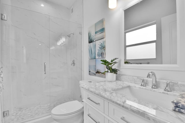 full bath with toilet, a marble finish shower, and vanity