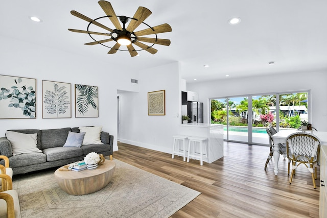 living area featuring ceiling fan, visible vents, baseboards, recessed lighting, and light wood-style flooring