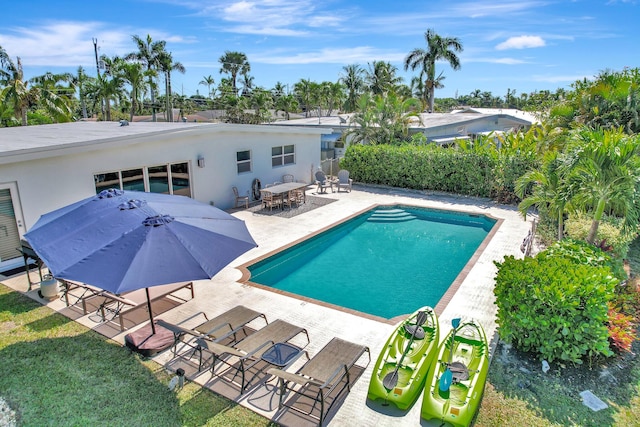 view of swimming pool with fence, a fenced in pool, outdoor dining area, and a patio area