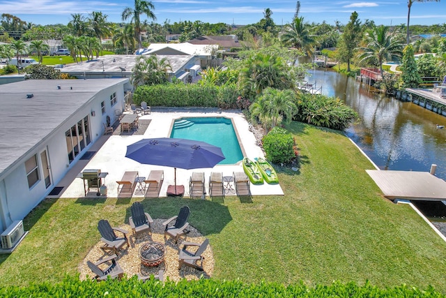 view of pool with a water view, a yard, an outdoor fire pit, and a patio area