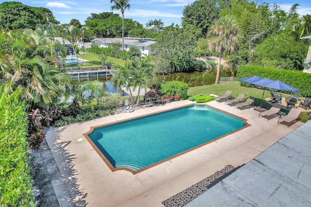 outdoor pool with a water view and a patio area