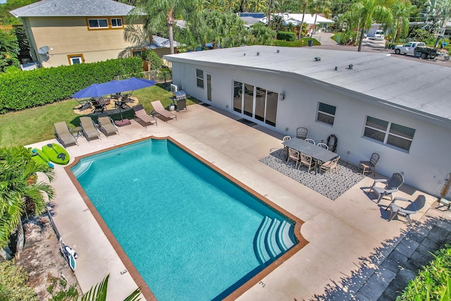 view of pool featuring a patio, outdoor dining area, a fenced in pool, and area for grilling