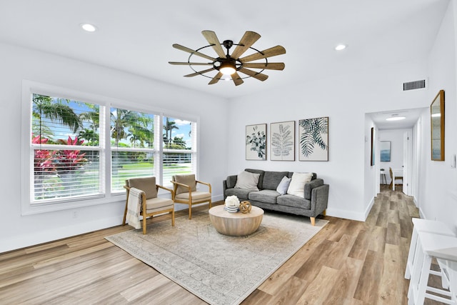 living room featuring ceiling fan, visible vents, baseboards, light wood finished floors, and recessed lighting