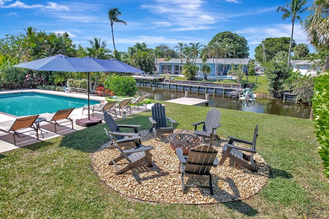 pool featuring a lawn, a patio, a water view, and an outdoor fire pit