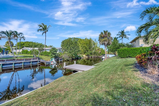 view of dock with a yard and a water view
