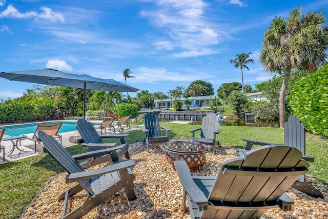 exterior space featuring a fire pit and an outdoor pool