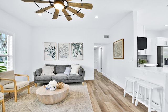 living area with visible vents, baseboards, ceiling fan, recessed lighting, and light wood finished floors