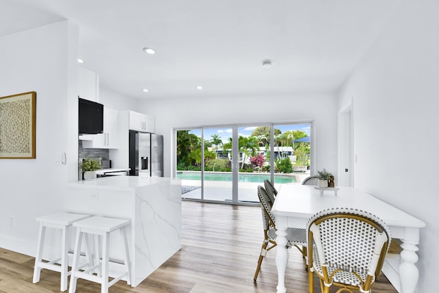 dining area featuring recessed lighting, baseboards, and light wood finished floors
