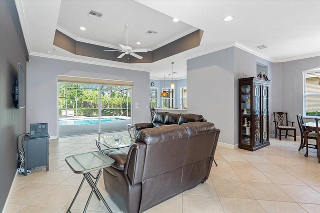 living room featuring light tile patterned floors, visible vents, ceiling fan, and plenty of natural light