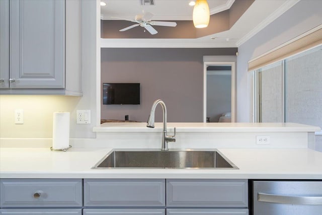 kitchen featuring light countertops, stainless steel dishwasher, crown molding, and a sink