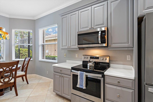 kitchen with gray cabinetry, baseboards, appliances with stainless steel finishes, and light countertops