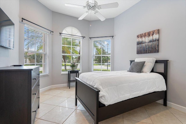 bedroom featuring light tile patterned floors, ceiling fan, and baseboards
