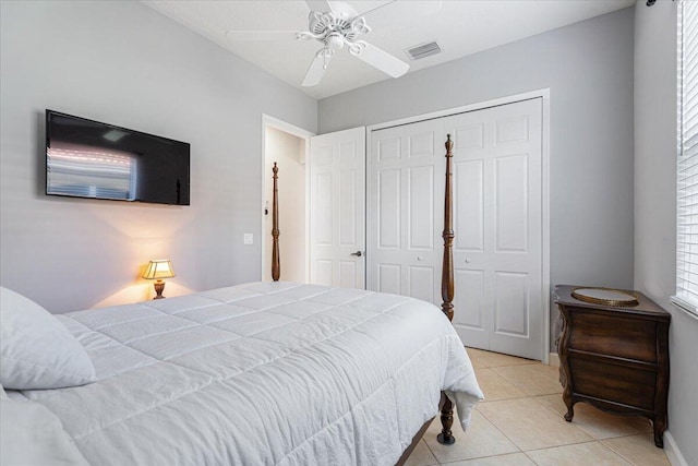 bedroom featuring a closet, ceiling fan, baseboards, visible vents, and light tile patterned flooring