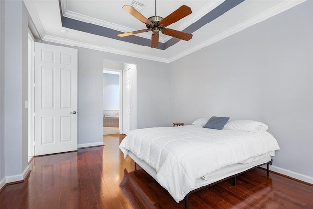 bedroom with a raised ceiling, hardwood / wood-style flooring, crown molding, and baseboards