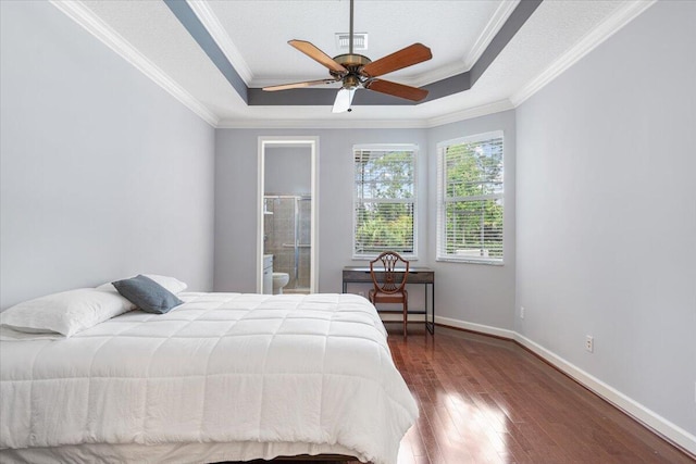 bedroom featuring hardwood / wood-style flooring, a raised ceiling, visible vents, baseboards, and ornamental molding
