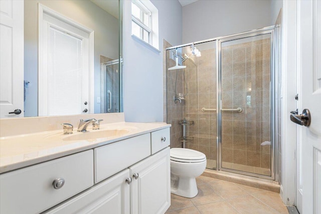 bathroom featuring toilet, a stall shower, tile patterned flooring, and vanity