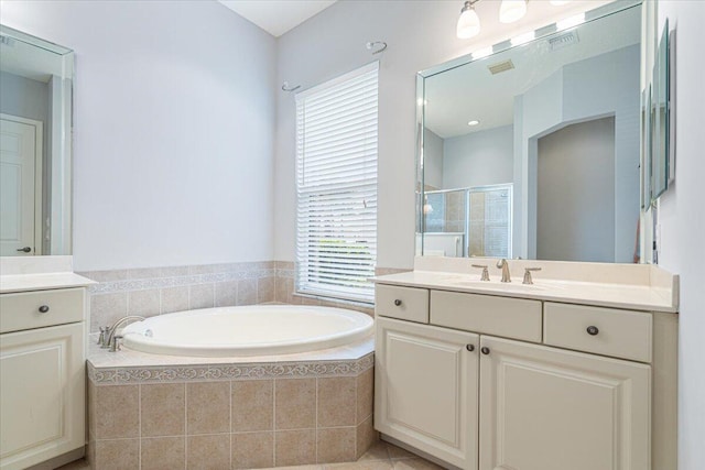 bathroom featuring visible vents, vanity, a bath, and a stall shower