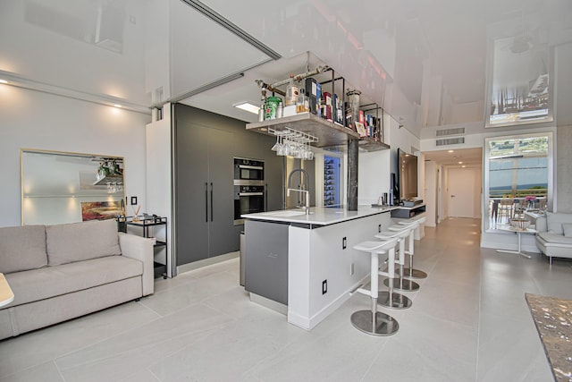 4101 N Ocean Blvd Unit 504, Boca Raton, FL 33431 - kitchen featuring a high ceiling, a sink, light tile patterned floors, a breakfast bar, and open floor plan