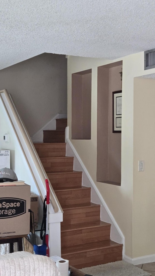 102 Weybridge Cir Unit D, Royal Palm Beach, FL 33411 - staircase featuring a textured ceiling