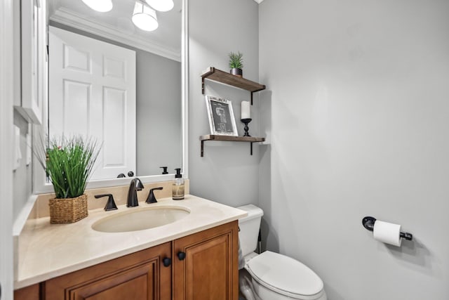 bathroom featuring crown molding, vanity, and toilet