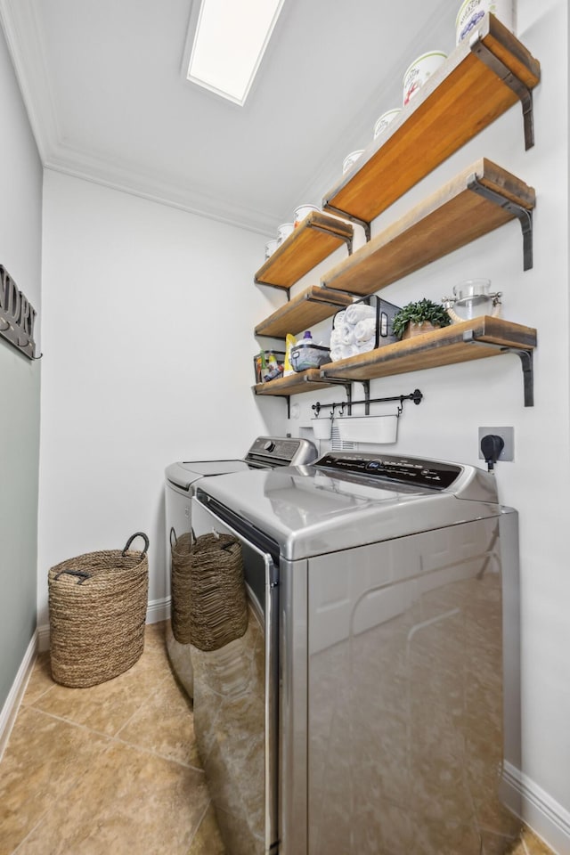 laundry area with laundry area, crown molding, washer and dryer, baseboards, and light tile patterned floors