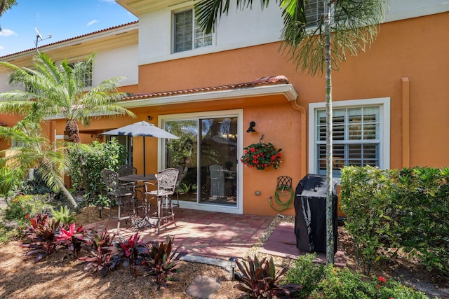 rear view of property featuring stucco siding and a patio area