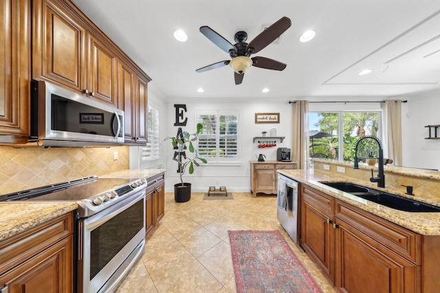 kitchen with a sink, decorative backsplash, stainless steel appliances, and plenty of natural light