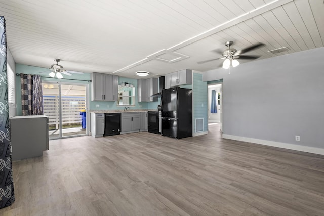 kitchen featuring wall chimney exhaust hood, gray cabinetry, ceiling fan, light countertops, and black appliances