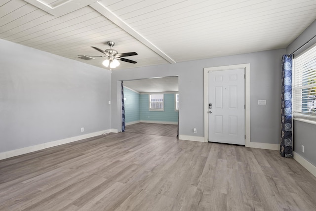 interior space with a ceiling fan, wood ceiling, light wood finished floors, baseboards, and beam ceiling