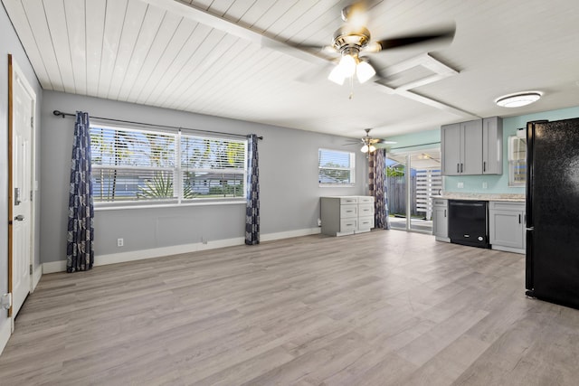 unfurnished living room with a ceiling fan, light wood-style flooring, and baseboards