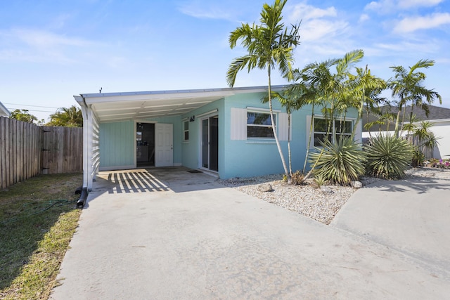 manufactured / mobile home with driveway, fence, and a carport
