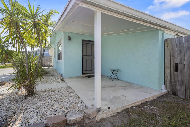 exterior space with stucco siding and fence