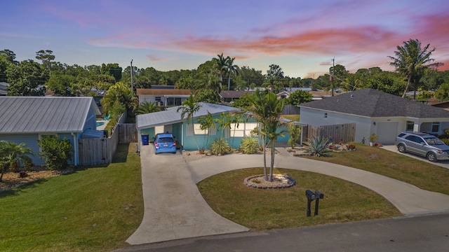 view of front of property with a front lawn, curved driveway, and fence