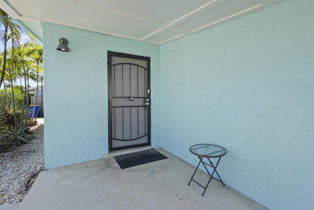 doorway to property featuring stucco siding