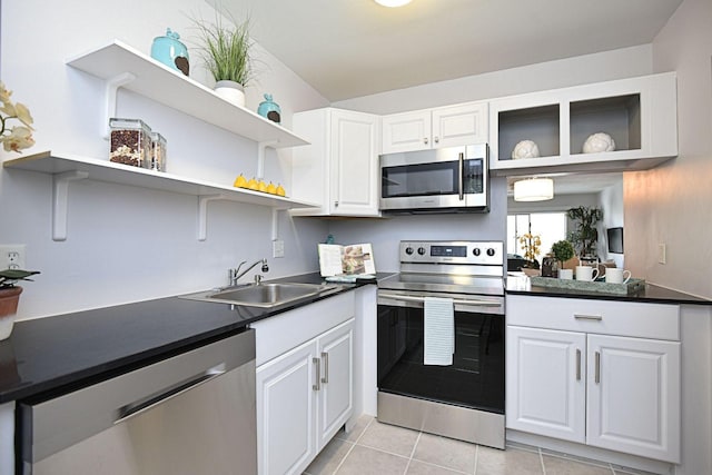 1432 S Lakeside Dr Unit 11, Lake Worth Beach, FL 33460 - kitchen with light tile patterned floors, appliances with stainless steel finishes, open shelves, and dark countertops