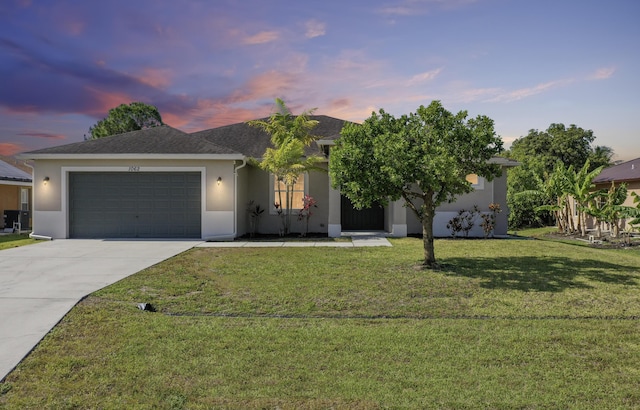 view of front of home with a yard, driveway, stucco siding, and an attached garage