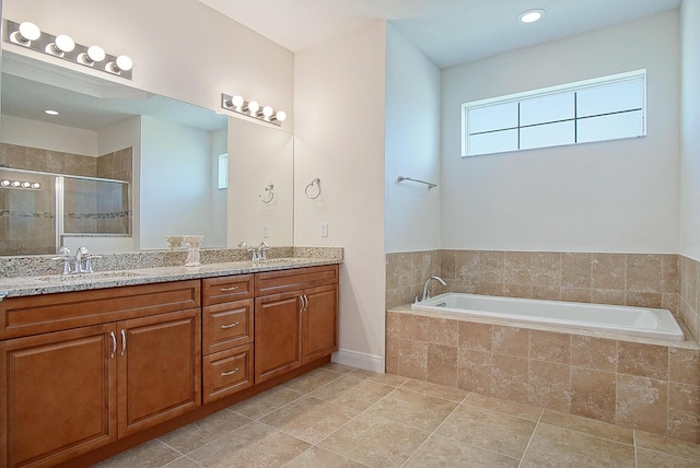 full bath with a sink, double vanity, a stall shower, and a bath