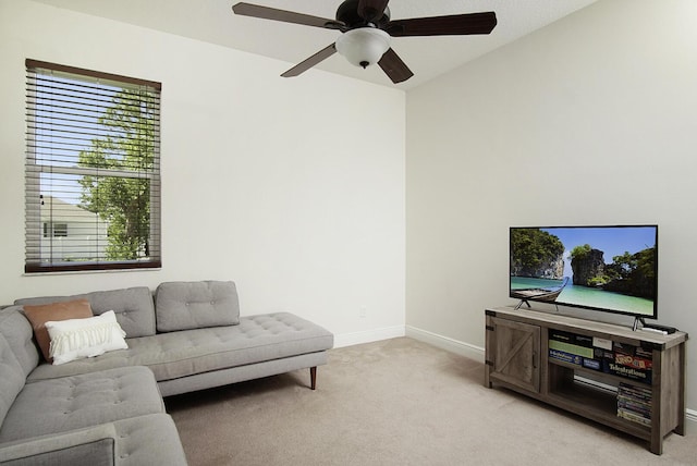 living room featuring baseboards, a ceiling fan, and light colored carpet