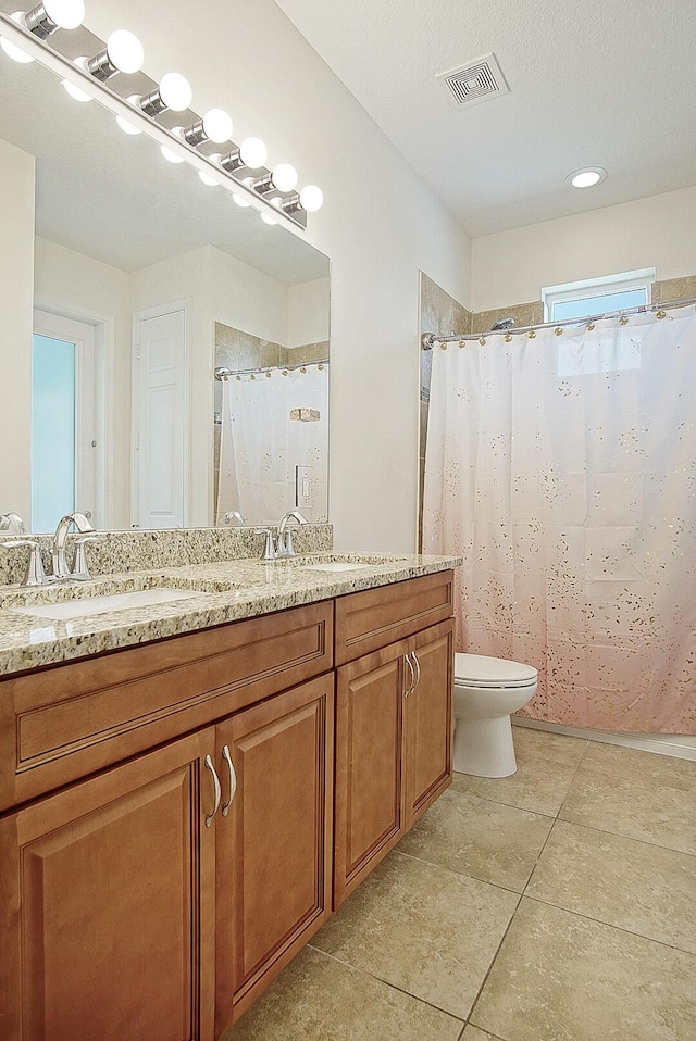 bathroom with toilet, tile patterned floors, vanity, and visible vents