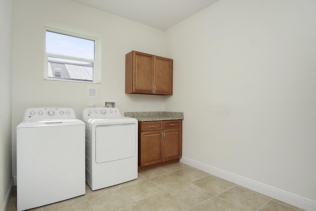 laundry area with light tile patterned flooring, cabinet space, baseboards, and independent washer and dryer