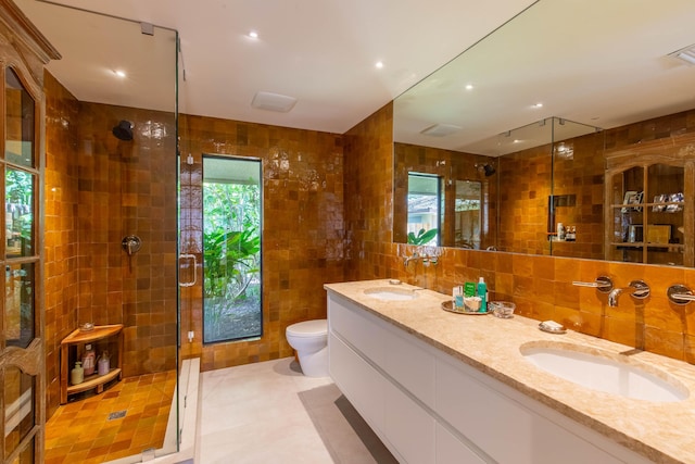 full bath featuring a sink, a shower stall, and tile walls