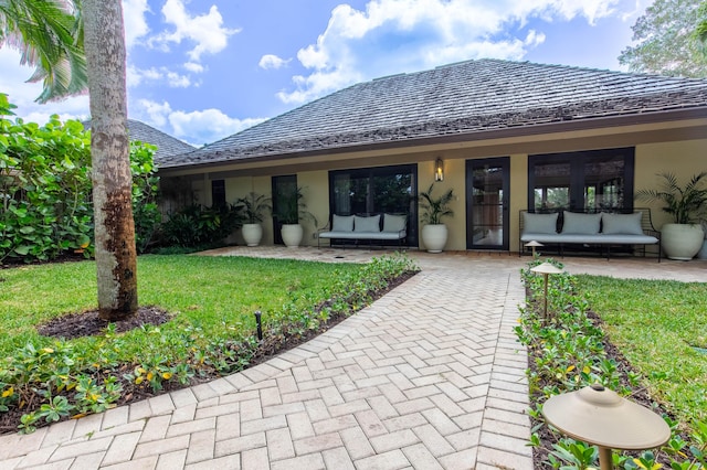 entrance to property with stucco siding and a yard