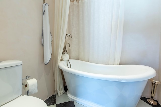 full bath with toilet and a soaking tub