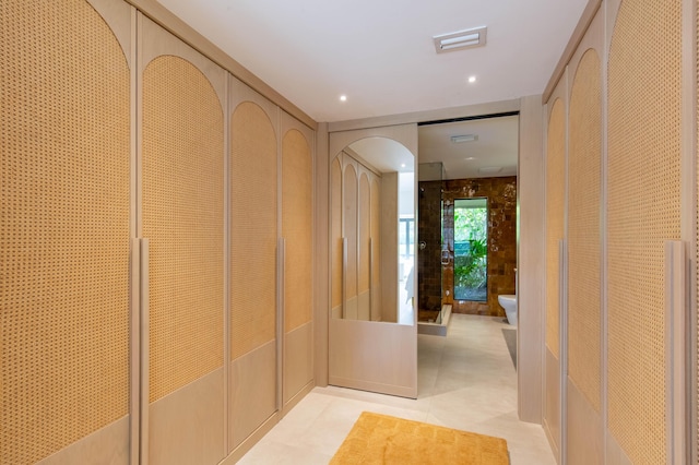 corridor with light tile patterned floors and arched walkways
