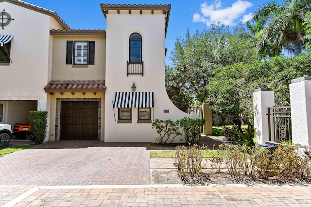210 Via Villagio, Hypoluxo, FL 33462 - mediterranean / spanish-style house with fence, decorative driveway, stucco siding, a tiled roof, and an attached garage