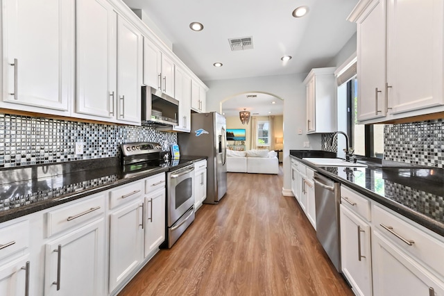 210 Via Villagio, Hypoluxo, FL 33462 - kitchen with visible vents, light wood-type flooring, white cabinetry, a sink, and appliances with stainless steel finishes