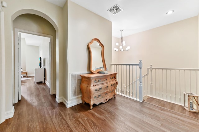 210 Via Villagio, Hypoluxo, FL 33462 - hallway with visible vents, arched walkways, wood finished floors, and a chandelier
