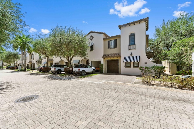 210 Via Villagio, Hypoluxo, FL 33462 - mediterranean / spanish-style house with a tiled roof, an attached garage, driveway, and stucco siding