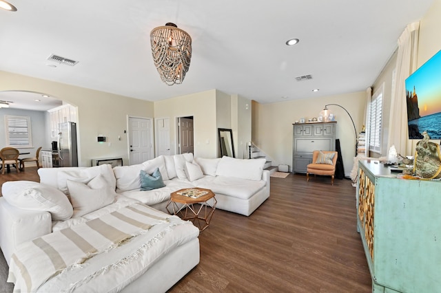 210 Via Villagio, Hypoluxo, FL 33462 - living room with visible vents, arched walkways, dark wood-style floors, and an inviting chandelier