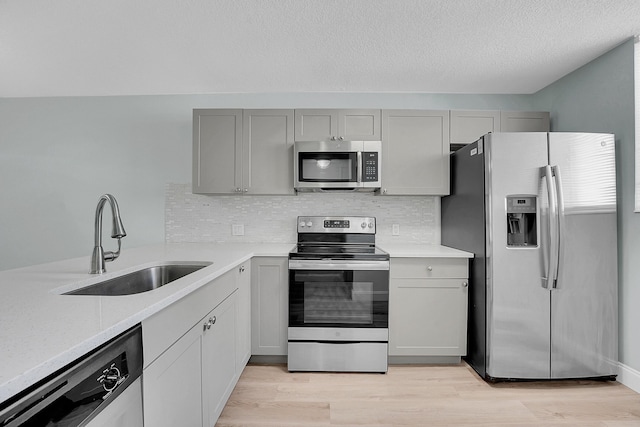 4345 Trevi Ct Unit 108, Lake Worth, FL 33467 - kitchen with appliances with stainless steel finishes, light countertops, tasteful backsplash, light wood-type flooring, and a textured ceiling